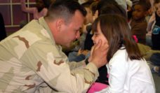 Soldier holding his young daughter's face in his hands