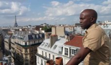 Djamil Bangoura on a rooftop in Paris with Eiffel Tower in the distance