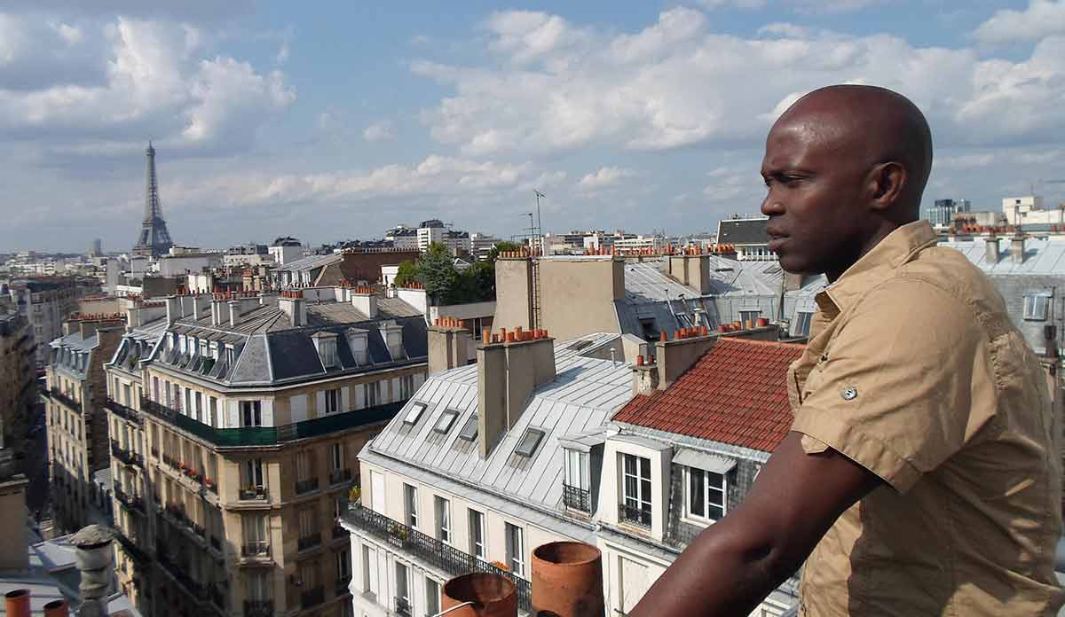 Djamil Bangoura on a rooftop in Paris with Eiffel Tower in the distance