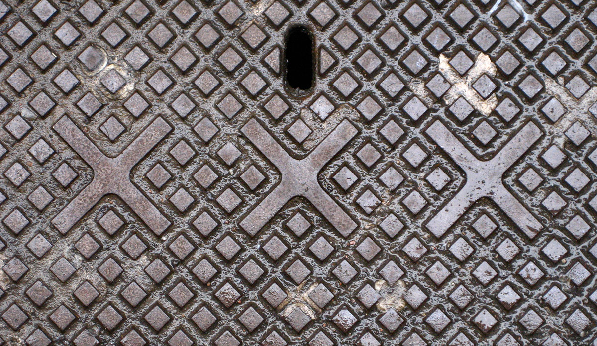 A manhole cover with three X's: XXX