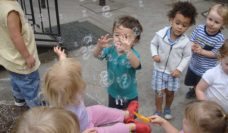 A group of children looking at bubbles in the air