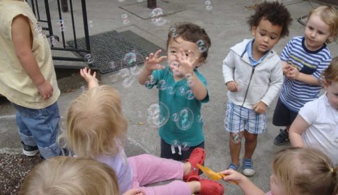 A group of children looking at bubbles in the air