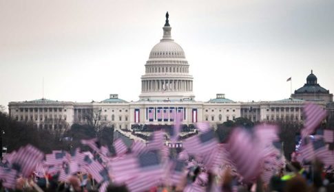 Crowd waving US flags in front of the US Capitol building at Obama inauguration