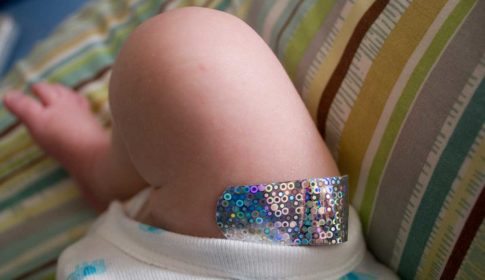 Infants leg with a sparkly vaccination bandaid