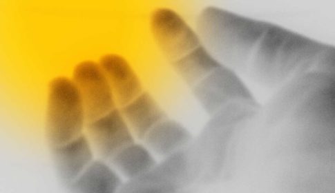 Shadowy hand with yellow glow on fingertips