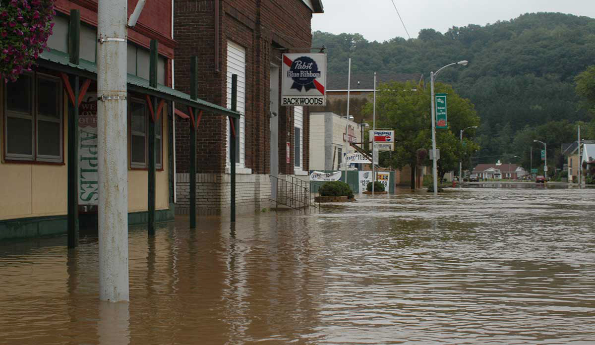 A street with floodwaters covering the sidewalks