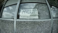 A fisheye lens view of a window with a handwritten sign saying HELP