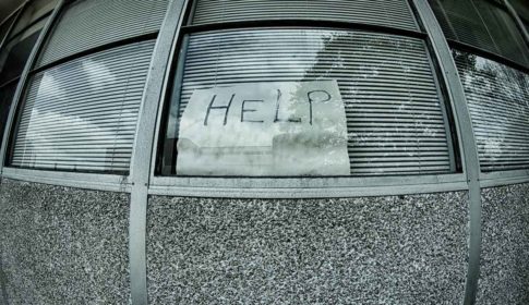 A fisheye lens view of a window with a handwritten sign saying HELP