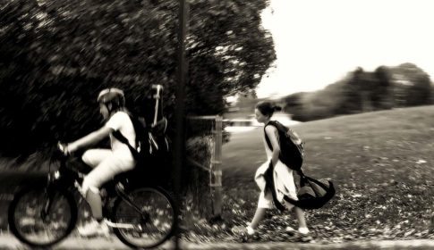 A boy on a bike and a girl walking