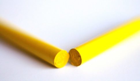 A yellow crayon broken in two pieces