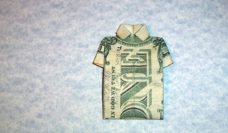 Dollar bill folded into a the shape of a shirt against a blue background