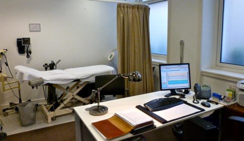 Doctors examination room with desk and computer