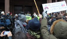 Women holds sign at Boston rally against Trump Muslim Ban 1.0. Photo © Gilbert Benavidez.