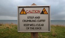 Caution sign: steep and crumbling cliff