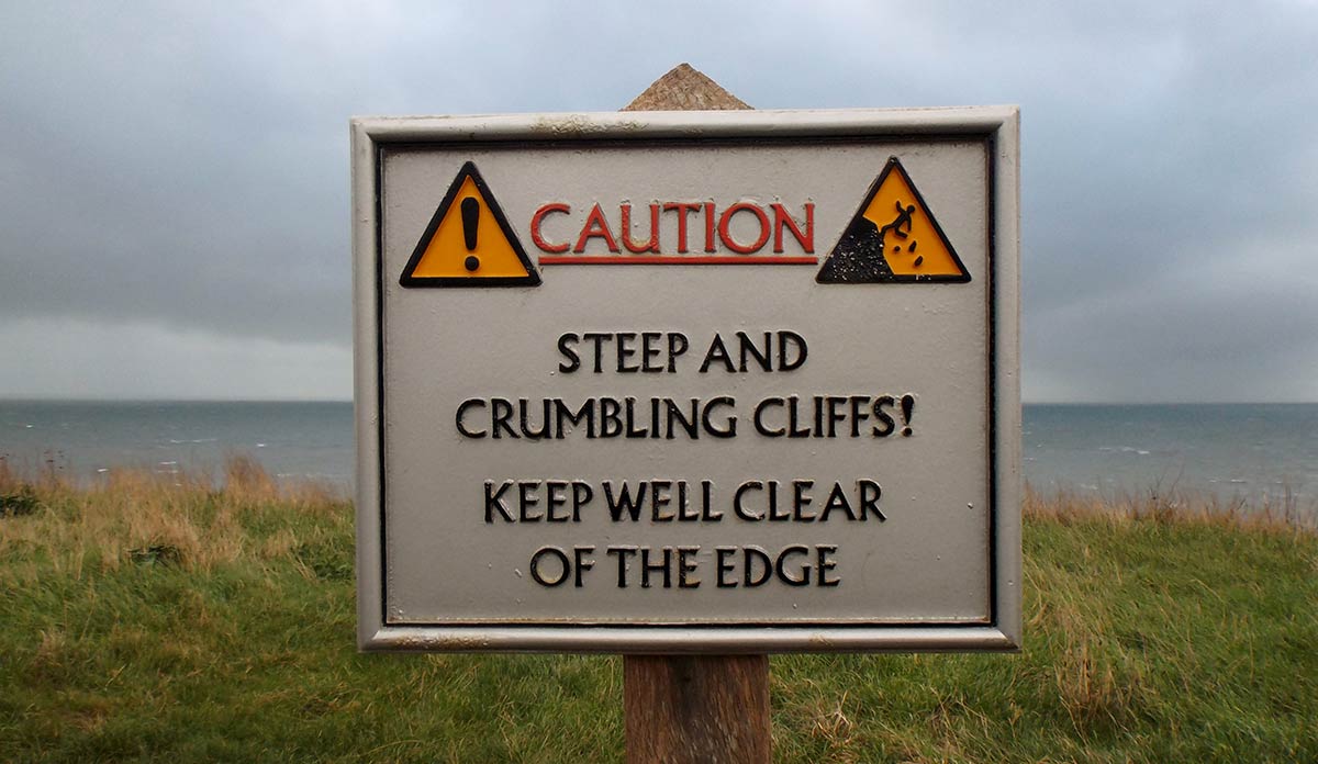 Caution sign: steep and crumbling cliff