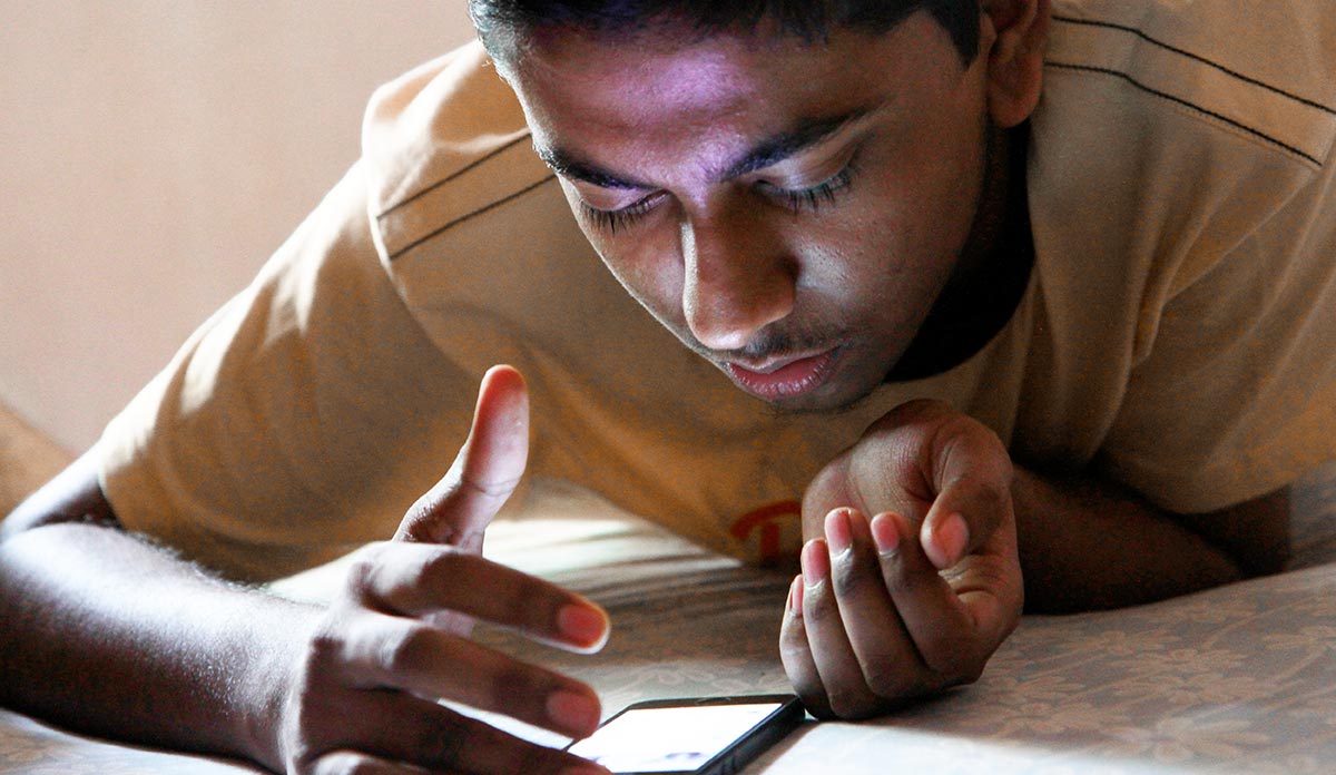 A teenage boy looking at his smartphone
