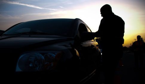 Policeman with a car at a DUI checkpoint at sunset