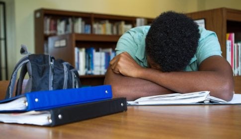 Young African American sleeping at the library