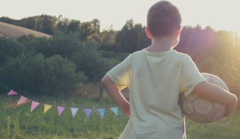 Boy with a soccer ball at twilight