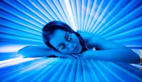 Young woman with google in tanning bed