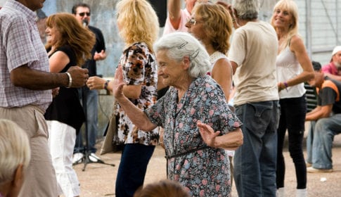 An older woman in a group dancing cumbia