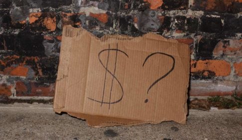 Cardboard sign with a dollar sign and a question mark