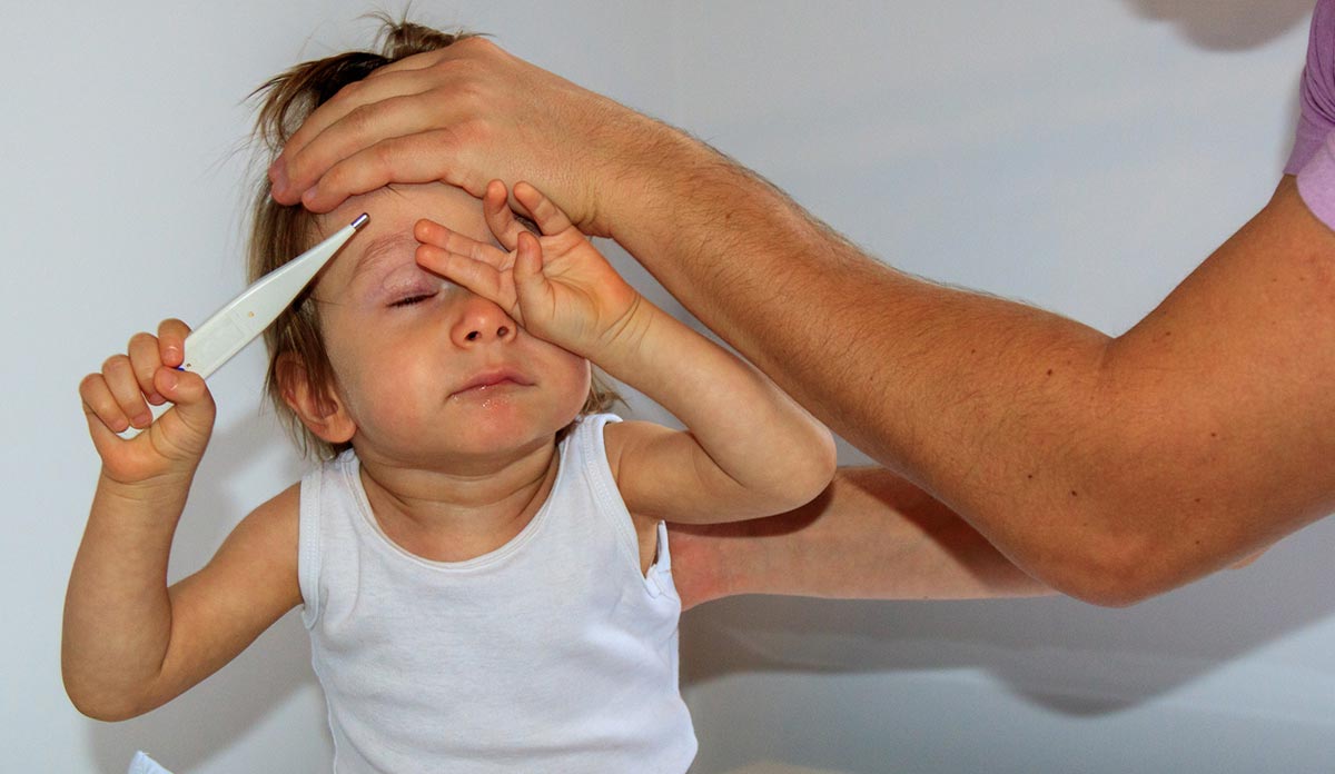 Parent putting hand on child's forehead