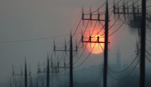Telephone poles and setting sun in heat haze