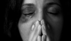 Closeup of a weeping woman's face with a black eye