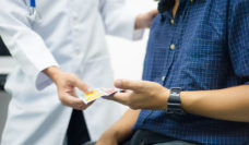 Medical provider handing condoms to a patient