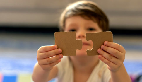 child holding puzzle piece