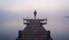 person on pier in fog