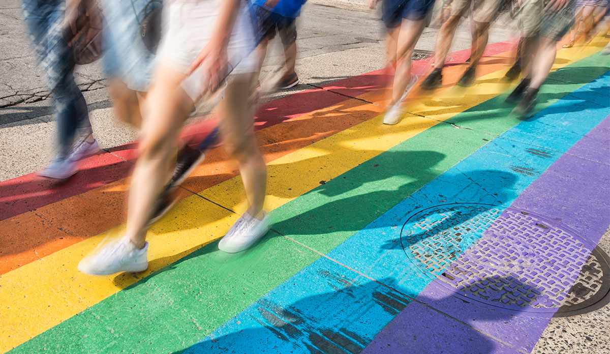 People walking in rainbow crosswalk