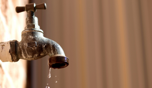 water drips from an old water faucet