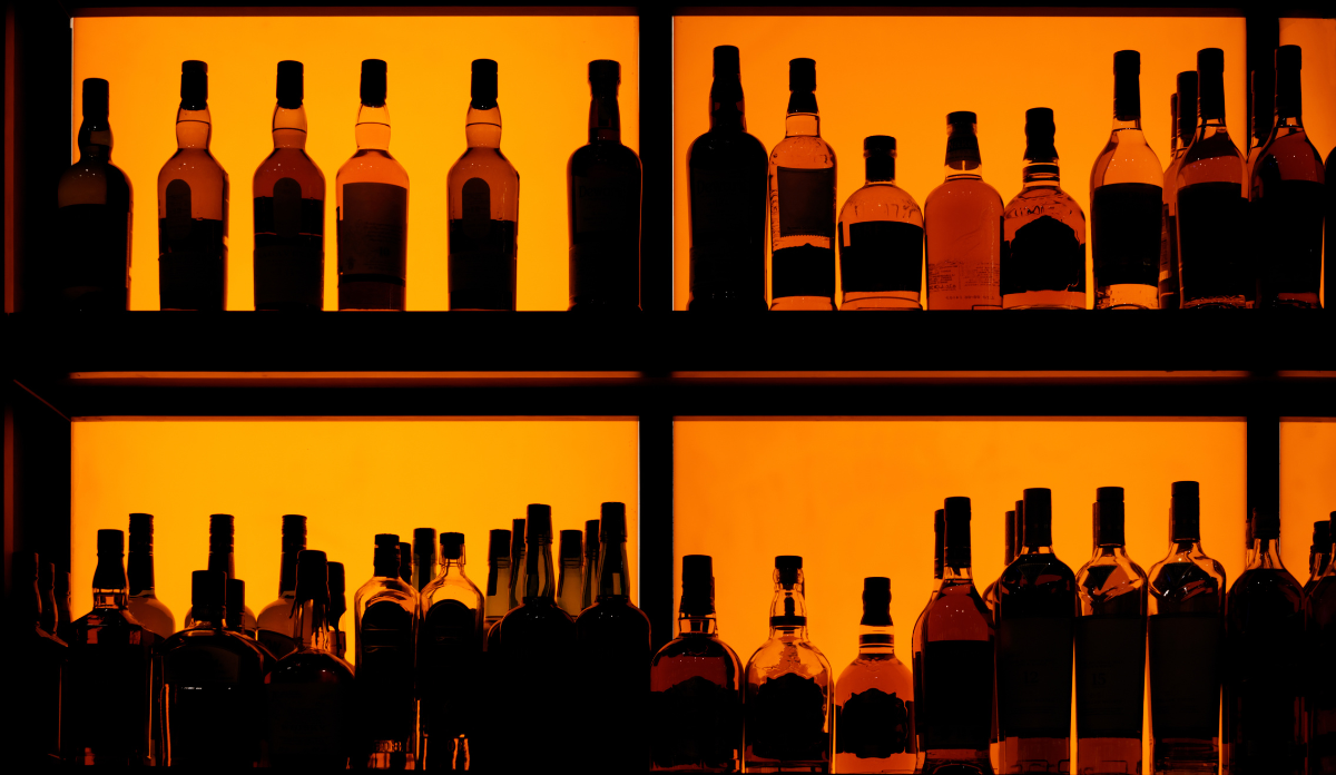 backlit bottles on shelf of bar