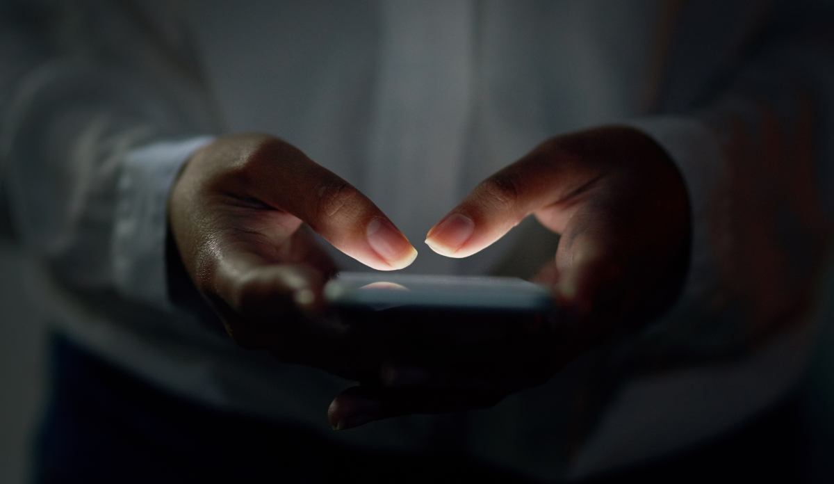 close up of hands holding lit up phone