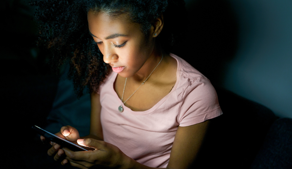 young adolescent girl scrolling through social media on her phone