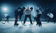two hockey players face off before puck is dropped by referee