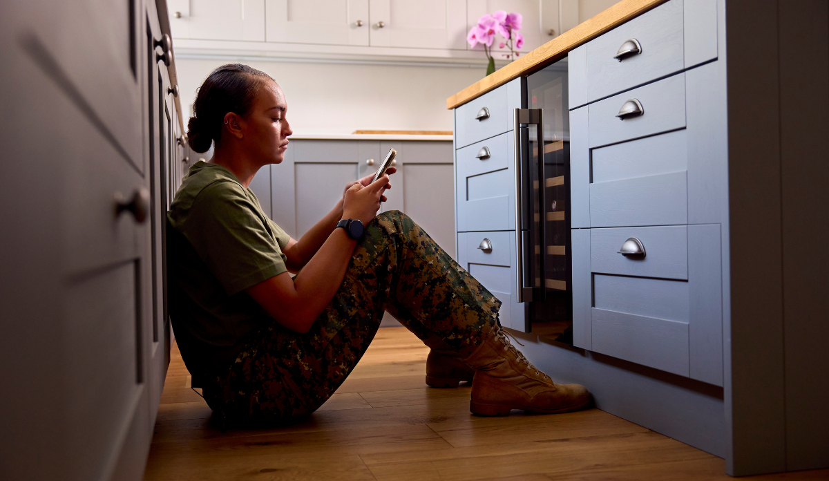 depressed veteran sitting on floor dialing phone