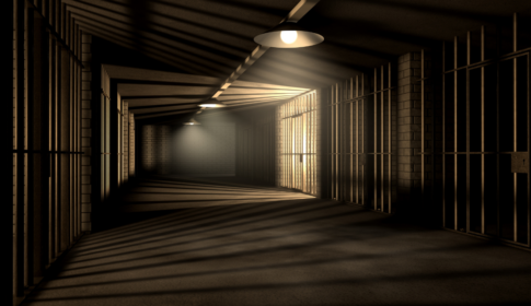 dark hallway lined with jail cells, depicting incarceration and the prison system