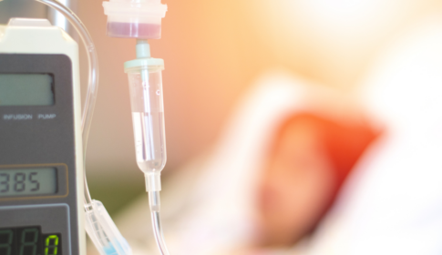 childhood cancer patient laying on bed with IV