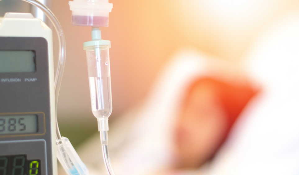 childhood cancer patient laying on bed with IV