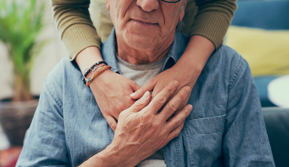 comforting hand on shoulder of elderly man