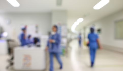 blurry image of health care workers walking around a hospital or clinical setting